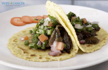 Two vegan tacos with cactus pico de Gallo and tomato garnish