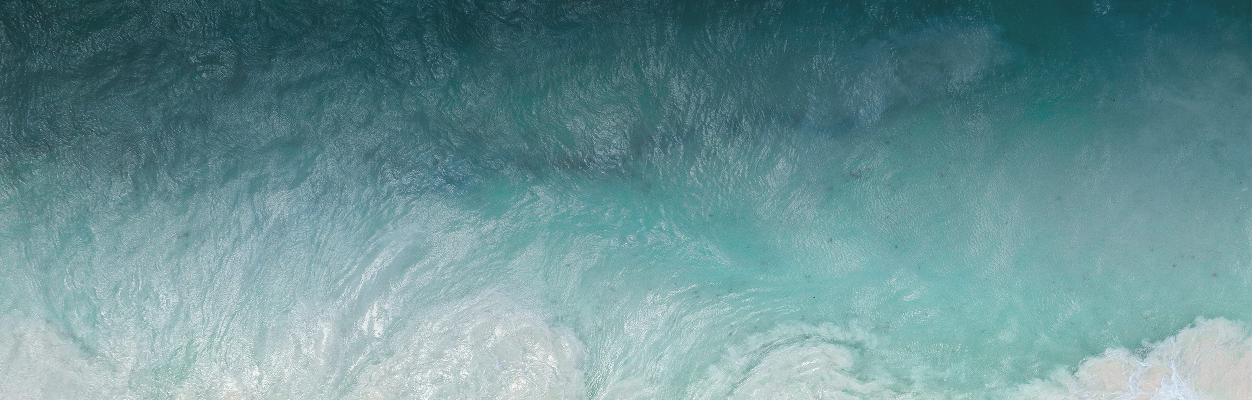 An aerial view of ocean waves on the beach
