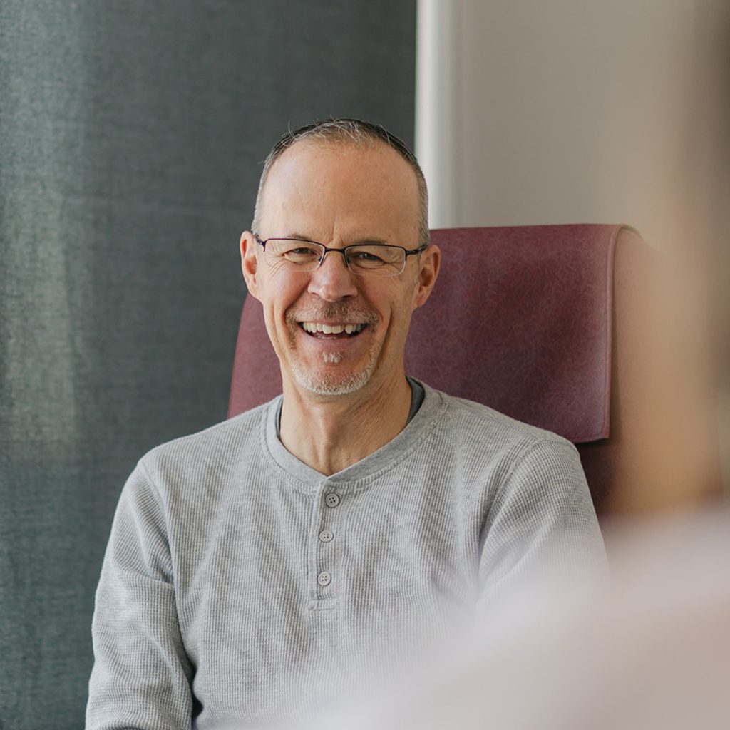 A smiling patient speaking with their doctor